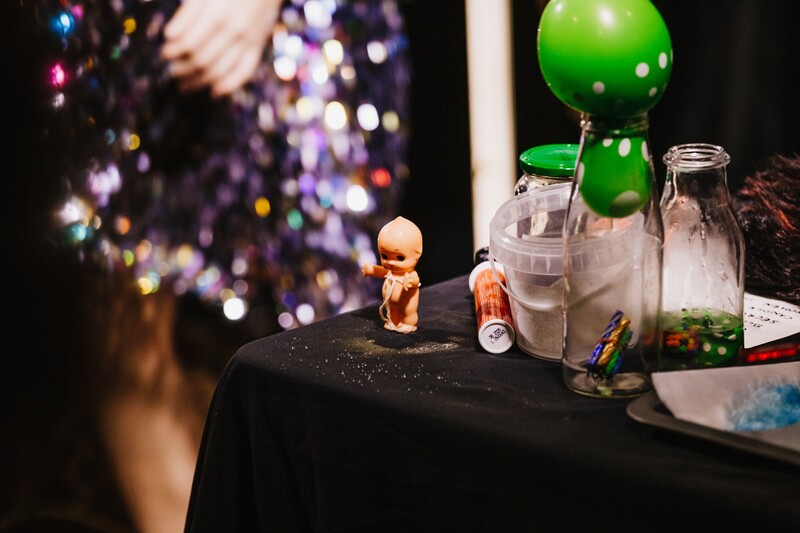 Kewpie doll, a balloon in a bottle and other props, Science with Raz at Sydney Comedy Festival 2019